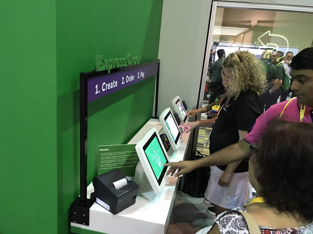 Early Subway self-service kiosk demonstration with customers at a wall-mounted ordering station
