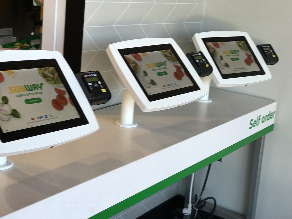 Multi-kiosk production configuration with integrated card-payment terminals on a counter